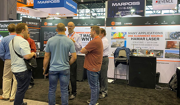 Hamar Laser booth at IMTS with visitors viewing precision laser alignment equipment.